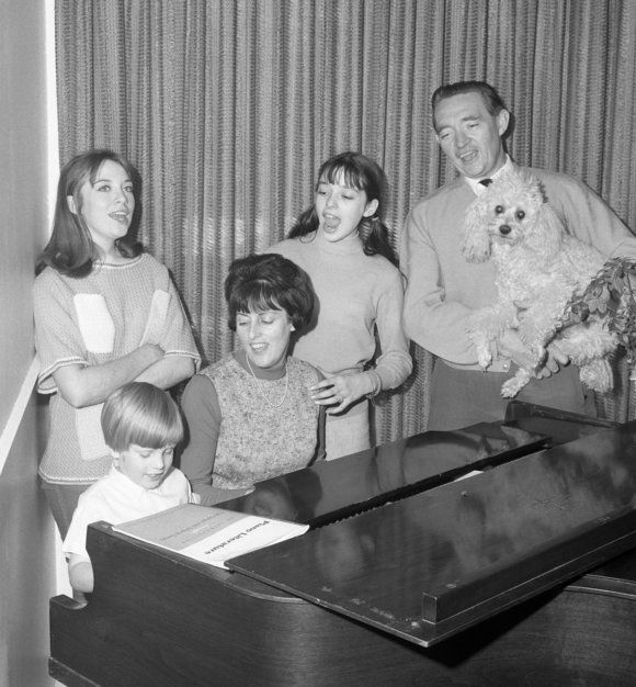 Family singing around the piano.