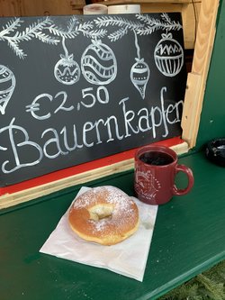 a cup of hot cider and a krapfen